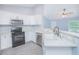 Open concept kitchen with white cabinetry, speckled countertops, and modern stainless appliances at 4911 Ne 7Th St, Ocala, FL 34470