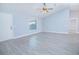 Bright, freshly painted living room with vaulted ceilings, ceiling fan, and grey vinyl flooring at 4911 Ne 7Th St, Ocala, FL 34470