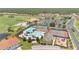 An aerial view displays a pool with a slide, playground, tennis courts, and clubhouse for residents at 561 Gunston Ct, Davenport, FL 33837