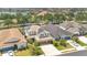 An aerial view shows the two-story home with a two car garage, solar panels, and beautiful landscaping at 561 Gunston Ct, Davenport, FL 33837