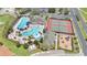 Aerial view highlighting the community pool area with slides, tennis courts, playground, and lush green spaces at 561 Gunston Ct, Davenport, FL 33837