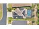 The aerial view captures a home with solar panels and a screened in backyard pool with an outdoor fire pit at 561 Gunston Ct, Davenport, FL 33837