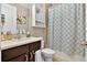 Cozy bathroom features a dark vanity, decorative shower curtain, and a mirrored medicine cabinet at 561 Gunston Ct, Davenport, FL 33837