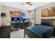 Bedroom features a dark bed frame, neutral walls, a computer gaming station, and windows for natural light at 561 Gunston Ct, Davenport, FL 33837
