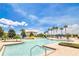 Large community pool with water slides, palm trees, lounge chairs, and umbrellas on a sunny day at 561 Gunston Ct, Davenport, FL 33837