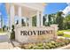 Providence community entrance sign with stone base and flowering garden in the foreground at 561 Gunston Ct, Davenport, FL 33837