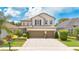 Charming two-story home boasts a well-manicured lawn, lush landscaping, and a convenient two-car garage at 561 Gunston Ct, Davenport, FL 33837