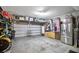 Spacious garage with storage shelving, an overhead rack, a stainless steel refrigerator, and epoxy floors at 561 Gunston Ct, Davenport, FL 33837