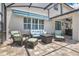 Relaxing outdoor seating area with comfortable wicker furniture, a sun awning, and a view of the backyard at 561 Gunston Ct, Davenport, FL 33837