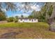 Large backyard featuring a well maintained lawn, trees, and wooden fence at 7330 Canal Dr, Sanford, FL 32771