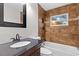 Nicely tiled bathroom featuring a tub with shower, tiled window, and wood vanity at 7330 Canal Dr, Sanford, FL 32771