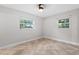 Bedroom featuring neutral walls, tile floor, ceiling fan, and two bright windows at 7330 Canal Dr, Sanford, FL 32771