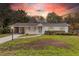 Charming single-story home featuring a well-maintained front yard, covered carport, and inviting entryway during sunset at 7330 Canal Dr, Sanford, FL 32771