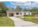 Inviting single-story home featuring a well-maintained front yard, covered carport, and charming entryway at 7330 Canal Dr, Sanford, FL 32771