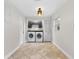 Well-organized laundry room with modern appliances, tiled floor, and storage cabinets at 7330 Canal Dr, Sanford, FL 32771