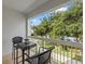 Tranquil balcony with seating provides a peaceful view of the lush greenery and swimming pool at 7615 Heritage Crossing Way # 201, Reunion, FL 34747
