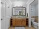 Well-lit bathroom with wooden cabinets and vanity, a large mirror, and a separate toilet room at 7615 Heritage Crossing Way # 201, Reunion, FL 34747