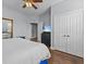 Bedroom features a large bed, and a view to the bathroom, ceiling fan, and hardwood floors at 7615 Heritage Crossing Way # 201, Reunion, FL 34747