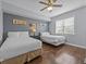 Charming bedroom features two beds, ceiling fan and hardwood floors, creating a comfortable retreat at 7615 Heritage Crossing Way # 201, Reunion, FL 34747