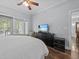 Bright bedroom with a view to the patio and backyard; features hardwood floors and a ceiling fan at 7615 Heritage Crossing Way # 201, Reunion, FL 34747