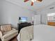 Bright bedroom featuring a ceiling fan, TV on a black dresser, and a comfortable armchair at 7615 Heritage Crossing Way # 201, Reunion, FL 34747