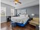 Bright bedroom features a large bed, hardwood floors, and a ceiling fan at 7615 Heritage Crossing Way # 201, Reunion, FL 34747