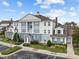 Attractive condo building exterior with blue and white facade, landscaping, and parking area at 7615 Heritage Crossing Way # 201, Reunion, FL 34747