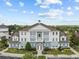 Inviting condo building featuring a light blue and white facade, columns, and lush landscaping at 7615 Heritage Crossing Way # 201, Reunion, FL 34747