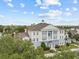 Gorgeous condo building with a blue and white exterior, complemented by mature trees and a bright sky at 7615 Heritage Crossing Way # 201, Reunion, FL 34747