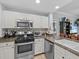 Kitchen featuring stainless steel appliances, granite countertops, and white cabinetry at 7615 Heritage Crossing Way # 201, Reunion, FL 34747