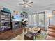 Comfortable living room featuring hardwood floors, a ceiling fan, and sliding glass doors to a balcony at 7615 Heritage Crossing Way # 201, Reunion, FL 34747