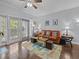 Living room with leather sofa, a ceiling fan, and sliding glass doors to a balcony at 7615 Heritage Crossing Way # 201, Reunion, FL 34747