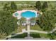Aerial view of a community pool, spa, and surrounding landscaping with lounge chairs at 7615 Heritage Crossing Way # 201, Reunion, FL 34747