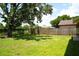 Green backyard with a wooden fence and mature trees providing ample shade at 7939 Winter Song Dr, Orlando, FL 32825