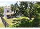 Aerial view of the expansive backyard featuring a covered patio, mature trees, and a fenced perimeter at 7939 Winter Song Dr, Orlando, FL 32825
