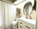 Neat bathroom featuring a stylish vanity, round mirror, and organized shelving for a clean look at 7939 Winter Song Dr, Orlando, FL 32825