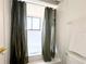 Bright bathroom with a tub and shower with dark green curtain, white tile and gold hardware at 7939 Winter Song Dr, Orlando, FL 32825