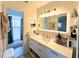 Modern bathroom featuring stylish vanity with gold hardware, illuminated mirror, and a shower with a curtain at 7939 Winter Song Dr, Orlando, FL 32825
