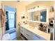 Modern bathroom features a large, backlit mirror, double vanity, and sleek gold hardware at 7939 Winter Song Dr, Orlando, FL 32825