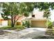 View of charming two-story home with two-car garage and mature shade tree at 7939 Winter Song Dr, Orlando, FL 32825