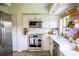 Well-lit kitchen with white cabinets, modern appliances, wood floors, and decorative shelving at 7939 Winter Song Dr, Orlando, FL 32825