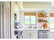 Bright kitchen featuring white cabinets, stainless steel appliances, and a large window overlooking the yard at 7939 Winter Song Dr, Orlando, FL 32825