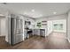 Renovated kitchen boasts lake view from adjacent room, stainless appliances, and modern gray cabinetry at 840 Bethune Dr, Orlando, FL 32810