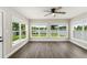 Bright living room features large windows with view of lake, ceiling fan, and wood-look flooring at 840 Bethune Dr, Orlando, FL 32810