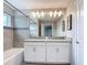 Bright bathroom with double sinks, gray countertops, and modern lighting fixture at 850 Pebble Beach Dr, Davenport, FL 33896