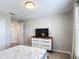 Spacious bedroom with modern dresser and tv, adjacent to the hallway and closet at 850 Pebble Beach Dr, Davenport, FL 33896