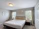 Neutral bedroom featuring carpeted floors, natural light, and stylish decor at 850 Pebble Beach Dr, Davenport, FL 33896