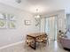 Well-lit dining room with view of chandelier, artwork, and view to covered pool area at 850 Pebble Beach Dr, Davenport, FL 33896