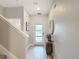 Bright foyer with tiled floors, complemented by a stylish console table and staircase at 850 Pebble Beach Dr, Davenport, FL 33896