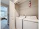 Bright laundry room featuring a white washer, dryer, and white wire shelf for convenient storage at 850 Pebble Beach Dr, Davenport, FL 33896